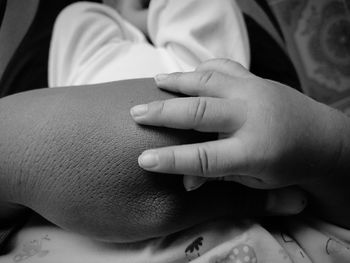 Close-up of baby and parent hands