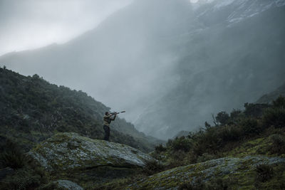Hunter in foggy mountains