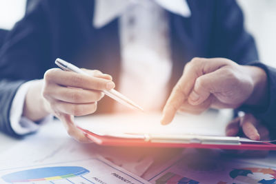 Close-up of businessman and colleague working over graph on table