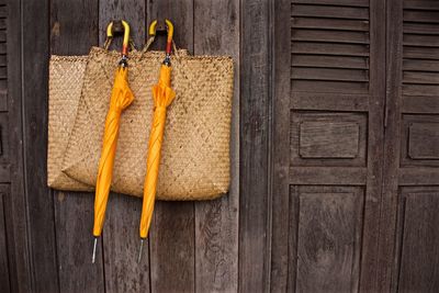Umbrellas and bag mounted on wooden wall