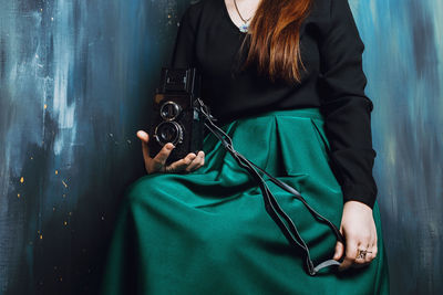 Midsection of woman holding camera