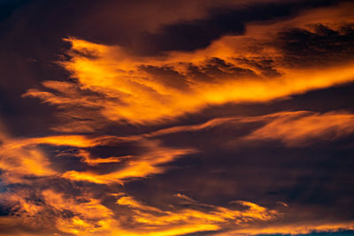 A landscape close up image of golden orange clouds during a sunset over the mediterranean wallpaper