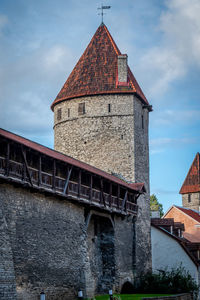 Low angle view of old building against cloudy sky