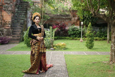 Portrait of woman standing against trees