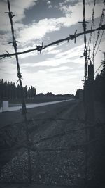 Electricity pylon against cloudy sky