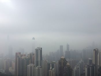 View of cityscape against sky during foggy weather