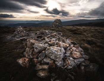 Rock formations on landscape against sky during sunset