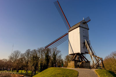 Traditional windmill on field against clear sky