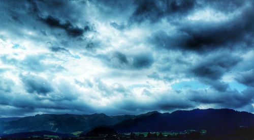 Scenic view of mountains against cloudy sky