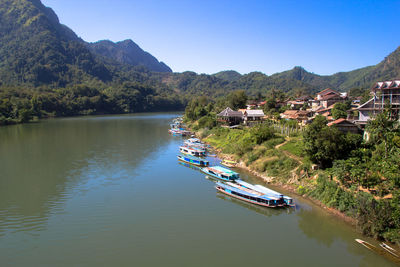 Scenic view of river and mountains against blue sky