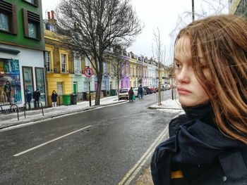 Teenage girl looking away on road in city