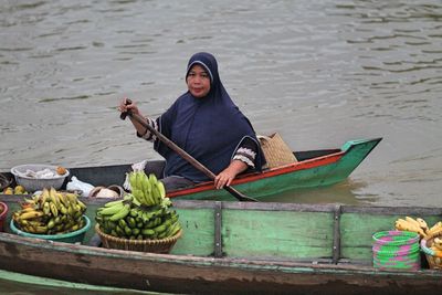 Woman selling food on boat in lake