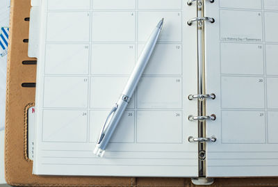 Directly above shot of pen and diary on table