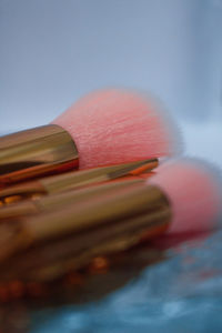 Close-up of pink makeup brushes on table