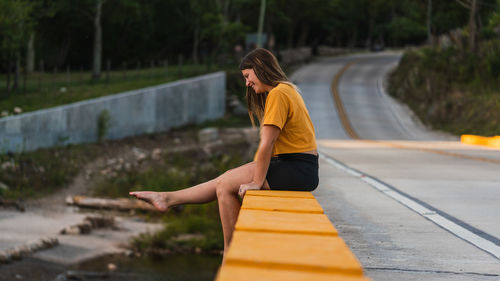 Full length of young woman on road