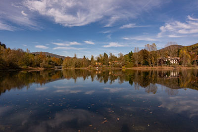 Scenic view of lake by trees against sky