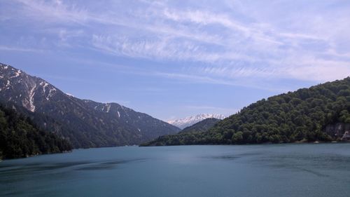 Scenic view of sea and mountains against sky