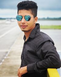 Portrait of young man standing at beach