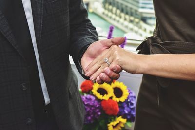 Midsection of bride and groom holding hands