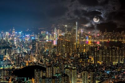 Illuminated cityscape against sky at night