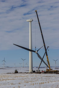 Traditional windmill on beach against sky