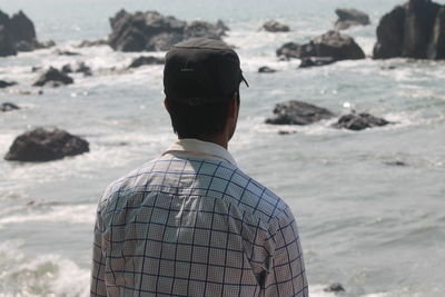 Woman standing on rocks at seaside