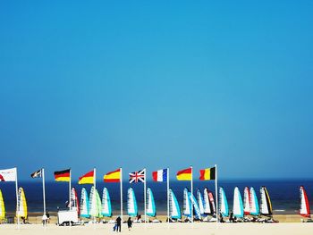 Chairs on beach against clear blue sky