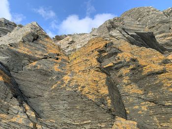 Low angle view of rocky mountains against sky