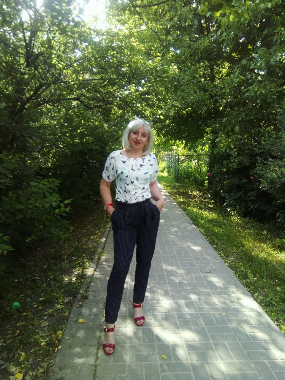 full length, plant, tree, one person, casual clothing, front view, standing, day, nature, looking at camera, portrait, real people, green color, child, leisure activity, outdoors, lifestyles, smiling, hairstyle