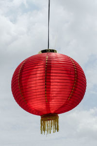 Low angle view of illuminated light bulb against sky