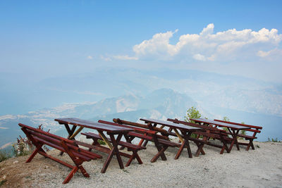 Travel background with rustic tables and benches at the nature, high in mountains