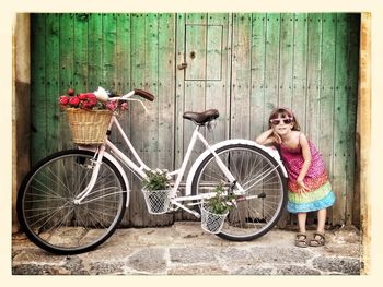 Girl standing next to bicycle
