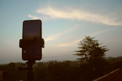 Low angle view of road signal against sky during sunset