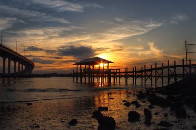 Pier on sea at sunset