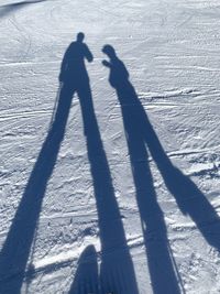 Shadow of people on snowcapped mountain during winter