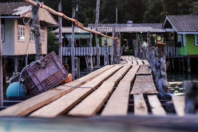 Empty benches by houses against trees