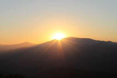 Scenic view of silhouette mountains against sky during sunset