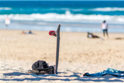 Deck chairs on sand at beach against sky