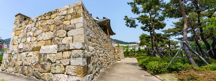 Stone wall of building against sky