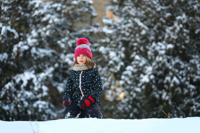 Winter portrait of a girl with a plastic sled sliding on a snowy slope 