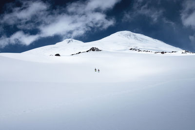 A team of two climbers with equipment goes up to the ascent