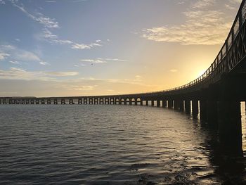 View of bridge over river against cloudy sky