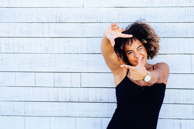 Young woman standing against wall