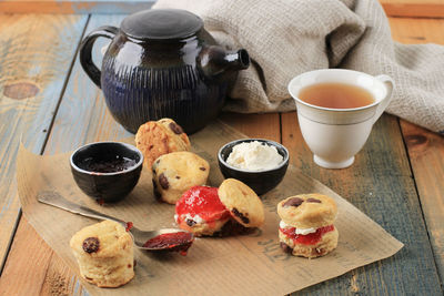 Traditional british scones with cream cheese, cranberry jam and a cup of tea 
