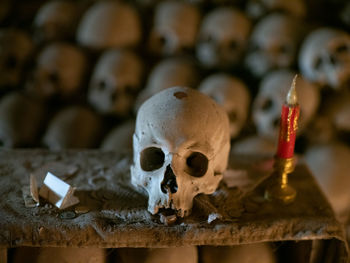 Close-up of human skull by candle on table