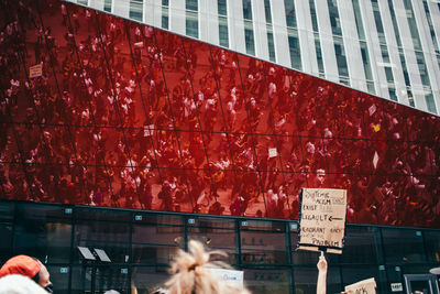 Low angle view of text on glass window of building