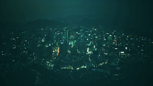 Aerial view of illuminated cityscape against sky at night