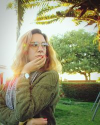 Portrait of young woman against trees