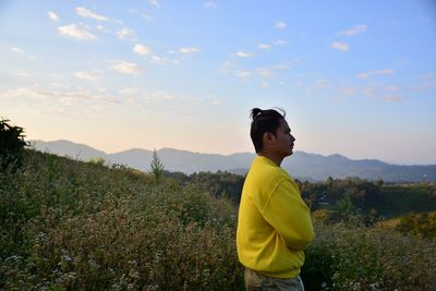 Side view of young man standing on land