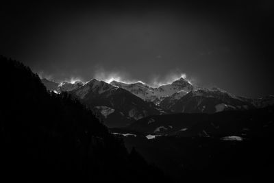 Scenic view of snowcapped mountains against sky at night